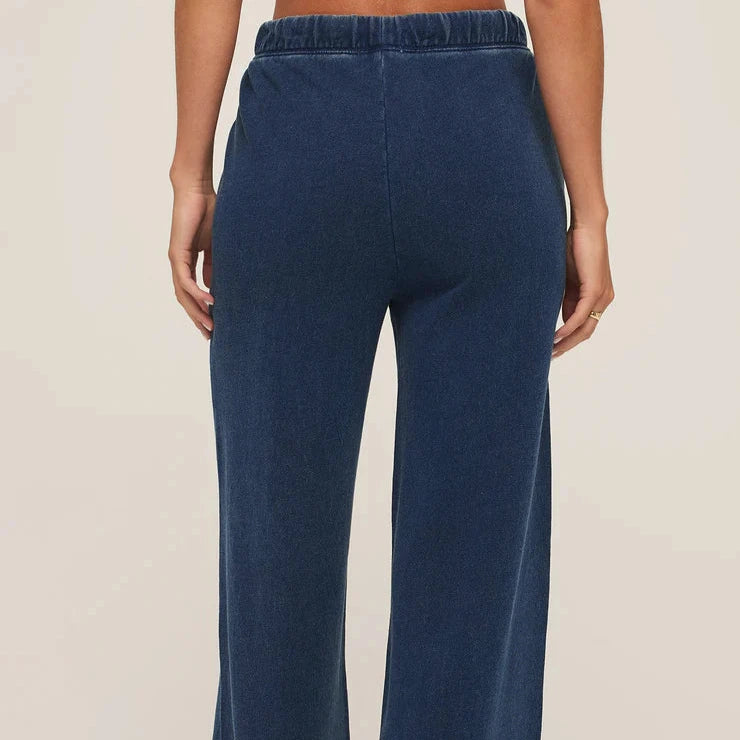 Navy blue wide-leg pants worn by a person on a beige background