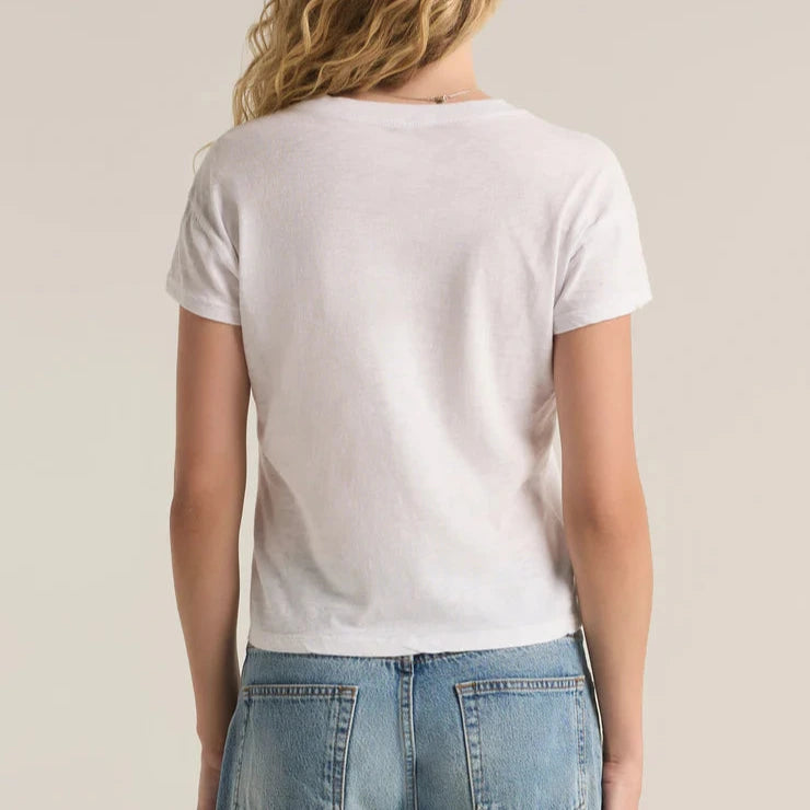 Person wearing a plain white t-shirt and blue jeans on a neutral background