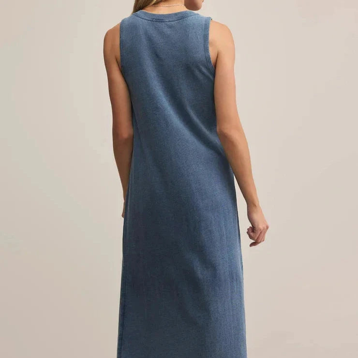 Woman wearing a blue sleeveless dress on a beige background