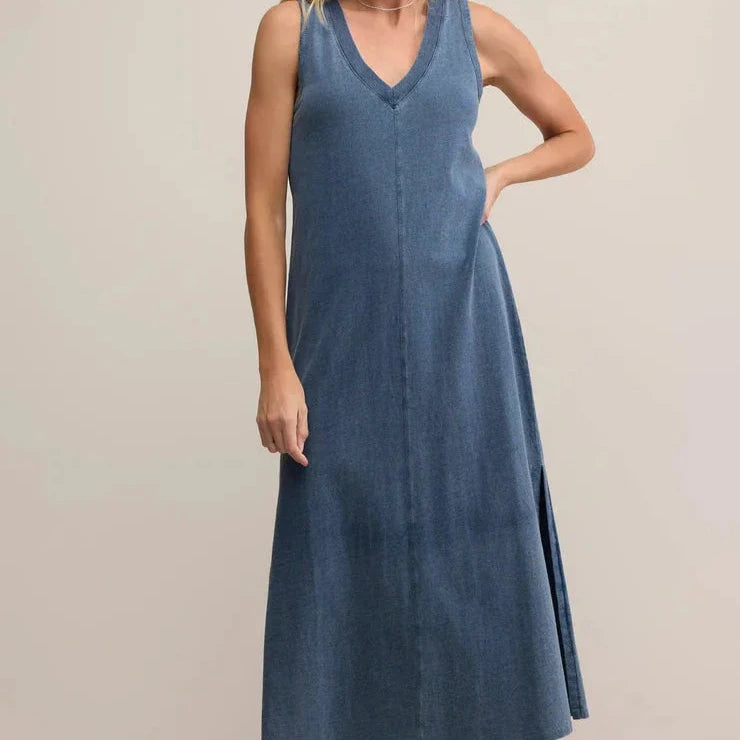 Woman wearing a blue sleeveless dress on a beige background
